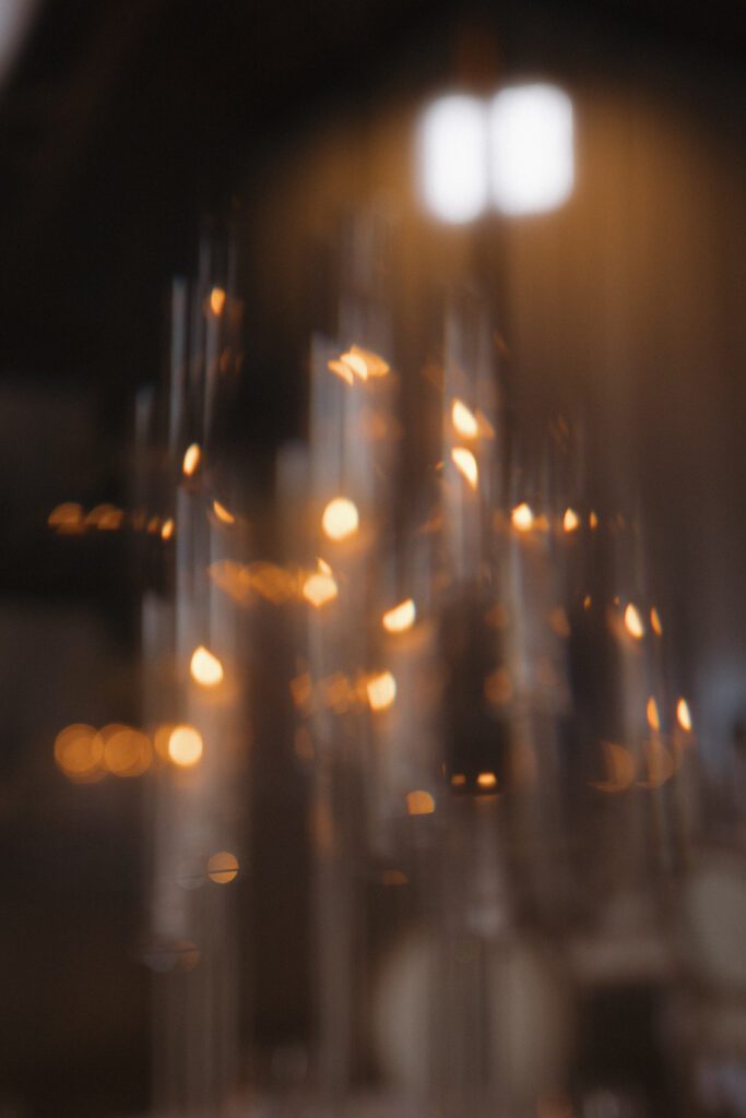 Elegant barn reception space at The Wells Estate in Avon, New York, featuring tall ceilings, soft candlelight, and refined decor
