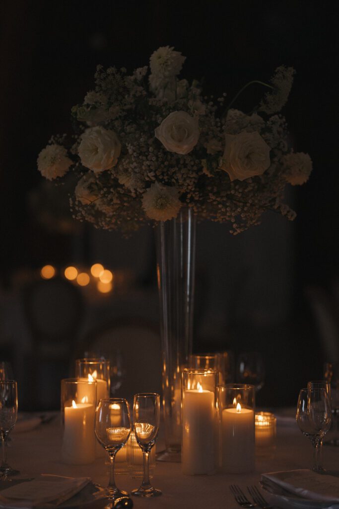 Elegant barn reception space at The Wells Estate in Avon, New York, featuring tall ceilings, soft candlelight, and refined decor